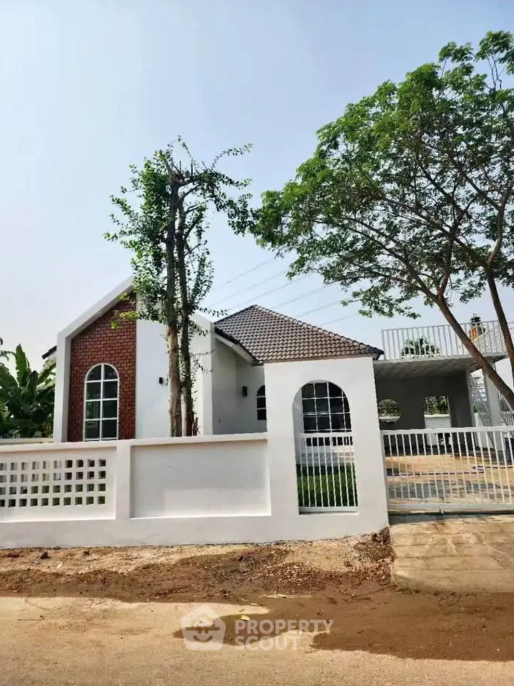 Charming modern house with white facade and lush greenery, perfect for serene living.