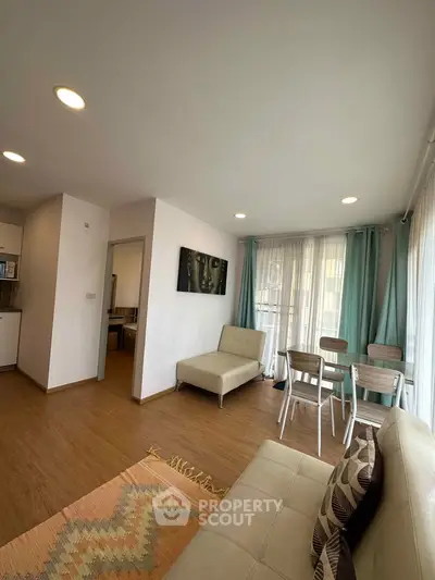 Modern living room with stylish decor and natural light, featuring a cozy seating area and dining space.