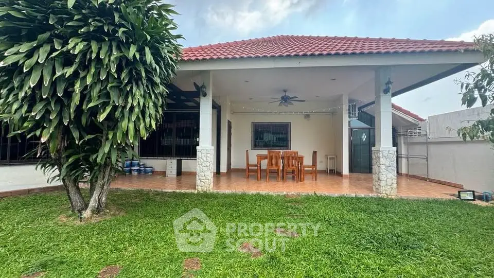 Charming single-story home with spacious patio and lush green garden, perfect for outdoor gatherings.