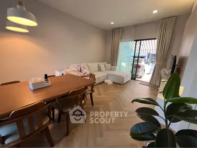 Spacious living room with modern decor and large windows leading to a balcony, perfect for relaxation.
