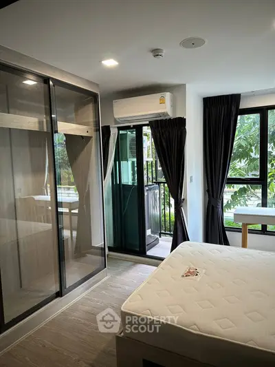 Modern bedroom with glass wardrobe and balcony view