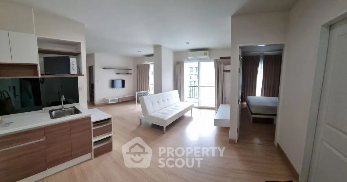 Modern open-plan apartment with sleek kitchen and spacious living area.