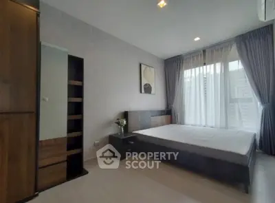 Modern bedroom with large window and stylish decor in a luxury apartment.