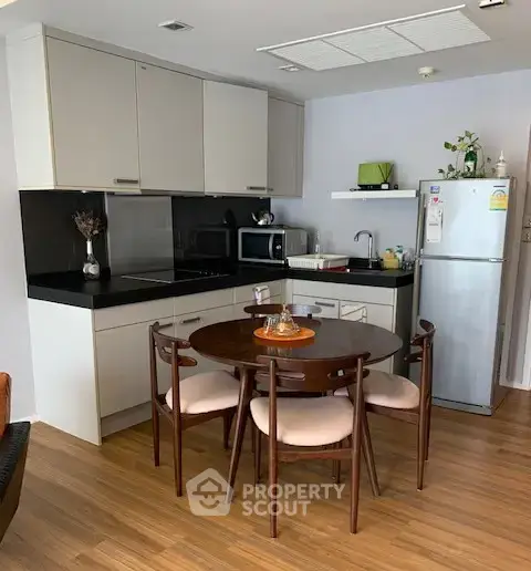 Modern kitchen with sleek cabinetry and dining area in stylish apartment