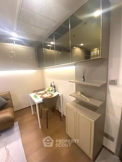 Modern living room with sleek cabinetry and cozy dining area in a stylish apartment.