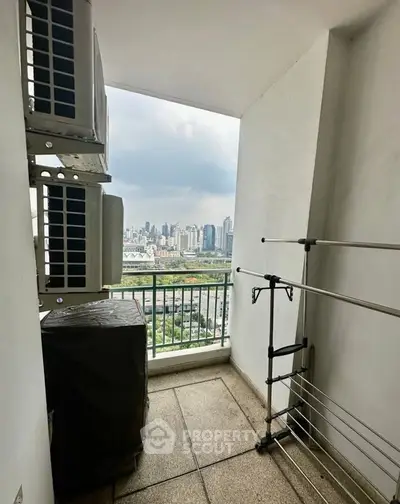 High-rise balcony with city view and air conditioning units, perfect for urban living.