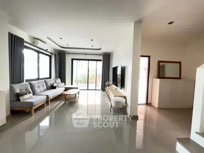 Spacious modern living room with sleek furniture and large windows for natural light.