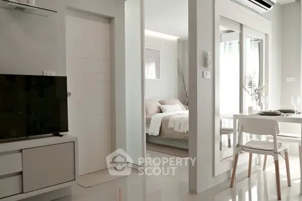 Modern open-plan living room with sleek furniture and cozy bedroom view