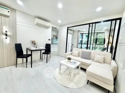 Modern living room with elegant decor and open layout, featuring a cozy sofa and dining area.
