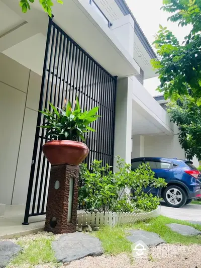 Modern home exterior with lush garden and carport