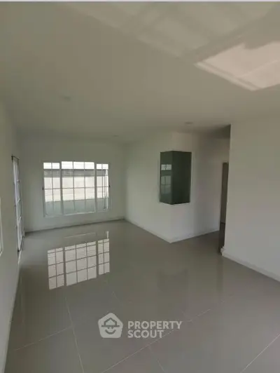 Spacious empty room with large windows and glossy tiled floor, perfect for customization.