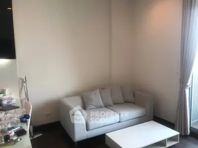 Cozy living room with modern sofa and natural light from large window.