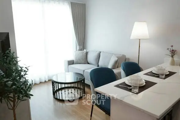 Modern living room with cozy sofa, stylish coffee table, and elegant dining area in open layout.