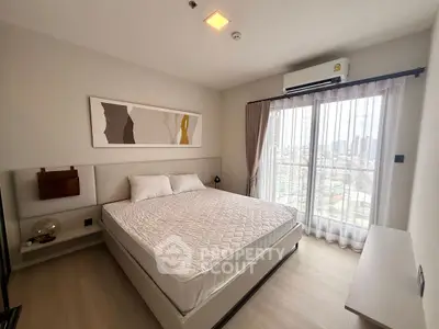 Modern bedroom with large window and city view, featuring stylish decor and natural light.