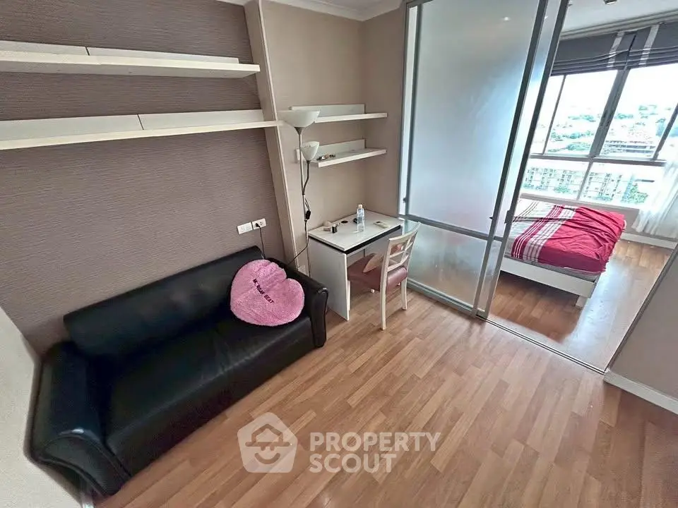 Modern apartment with cozy living area and stylish bedroom featuring large windows and wooden flooring.