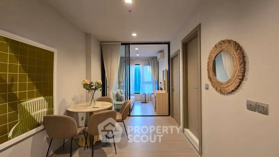 Modern apartment interior with stylish dining area and cozy living room, featuring elegant decor and natural lighting.
