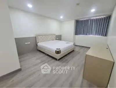 Spacious bedroom with modern design and natural light, perfect for relaxation.