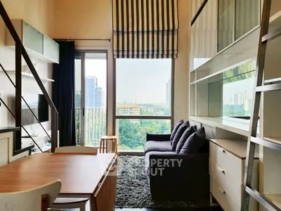 Modern living room with large window and city view, stylish furniture, and cozy ambiance.