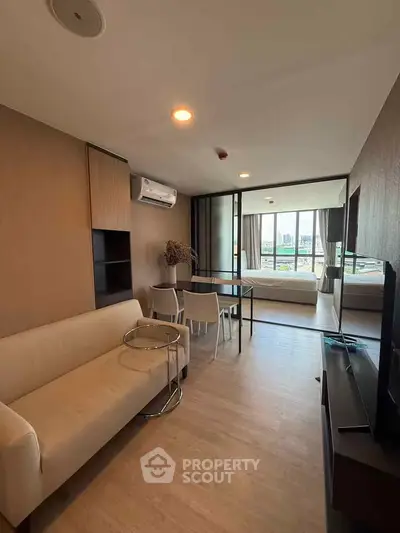 Modern open-plan living room with stylish furniture and city view, perfect for urban living.