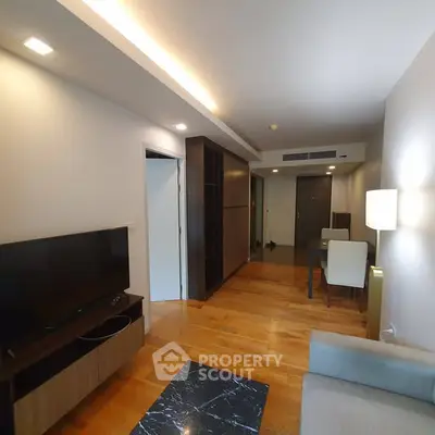 Modern living room with wooden flooring and sleek furniture in a stylish apartment.