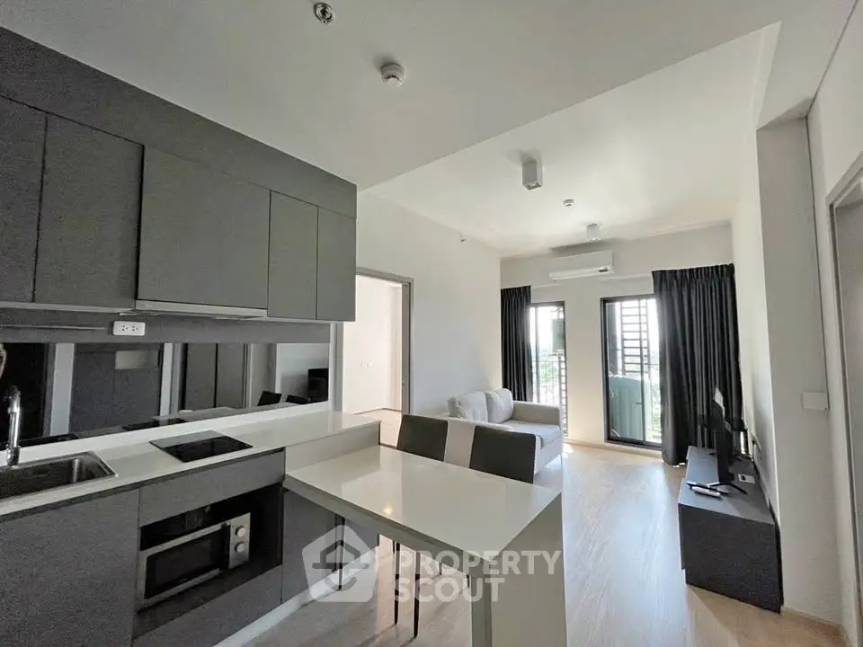 Modern open-layout kitchen and living room with sleek design and natural light.