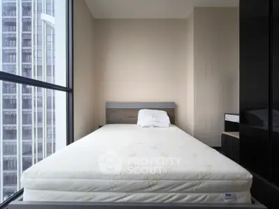 Modern bedroom with large window offering city view, featuring minimalist design and natural light.