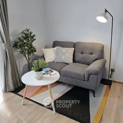 Cozy living room with stylish gray sofa, modern floor lamp, and chic decor accents.