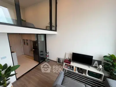 Modern loft apartment with stylish living room and compact kitchen, featuring sleek design and natural light.