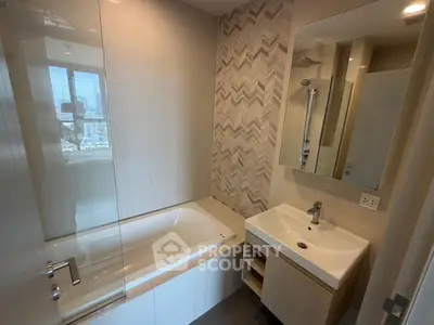 Modern bathroom with stylish tile design and bathtub in a contemporary apartment.