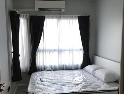 Bright bedroom with large windows and modern air conditioning unit.