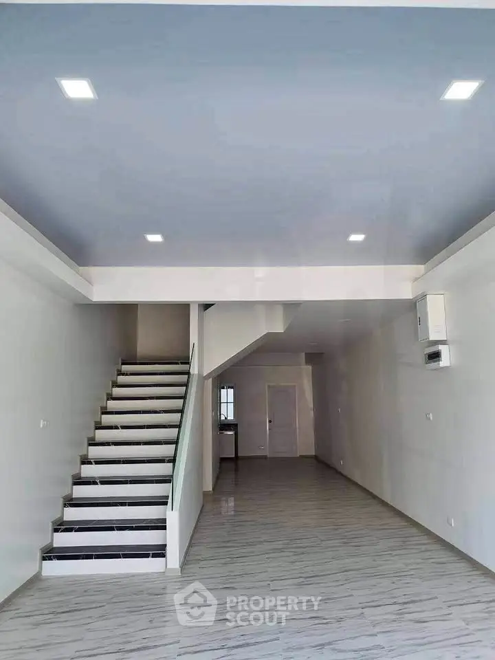 Spacious modern interior with sleek staircase and open layout, perfect for customization.