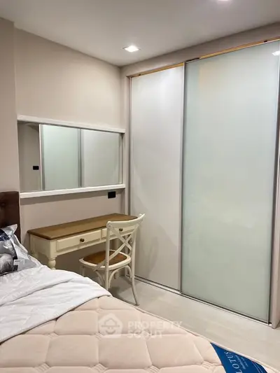 Cozy bedroom with elegant sliding closet doors and a stylish vanity desk, perfect for modern living.