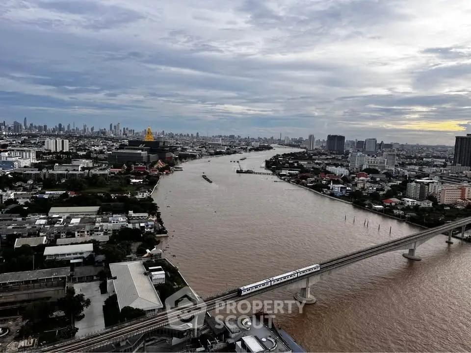 Stunning aerial view of a cityscape with river and skyline, showcasing urban development and transportation.