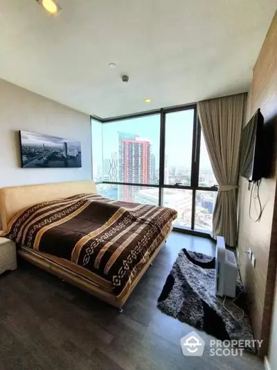 Modern bedroom with floor-to-ceiling windows offering a panoramic city view, complemented by sleek wooden flooring and tasteful decor.