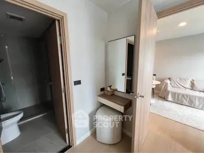 Modern apartment interior with cozy living room and stylish bathroom entrance.