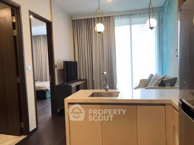 Modern open-layout kitchen with island and cozy living area in stylish apartment.