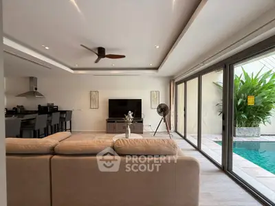 Luxurious living room with pool view, modern decor, and open layout in a high-end property.