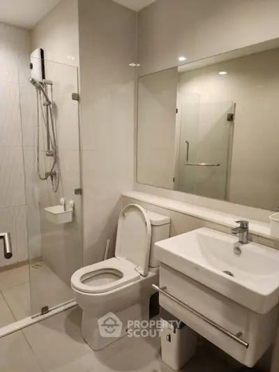 Modern bathroom with glass shower and sleek fixtures in a contemporary apartment.