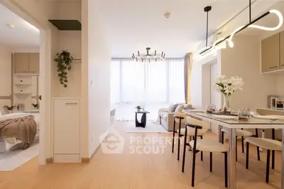 Modern open-plan living and dining area with stylish lighting and cozy bedroom view.