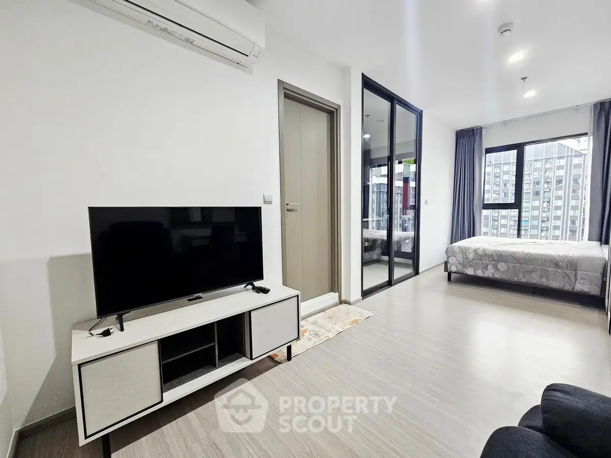 Modern apartment interior with sleek design and large windows offering city views.