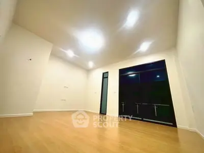 Spacious modern living room with large windows and wooden flooring