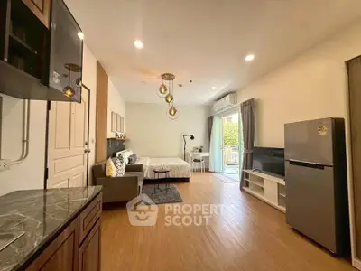 Modern studio apartment with open layout, featuring a cozy living area, stylish kitchen, and bright balcony access.