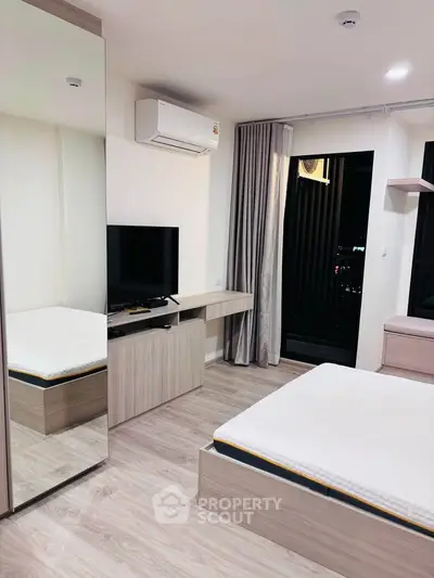 Modern bedroom with sleek furniture and large mirror in a stylish apartment.