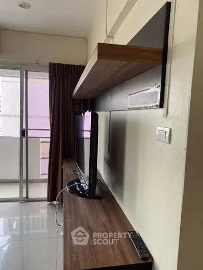 Modern living room with sleek TV setup and balcony access