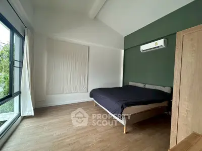 Spacious bedroom with modern design and large window for natural light