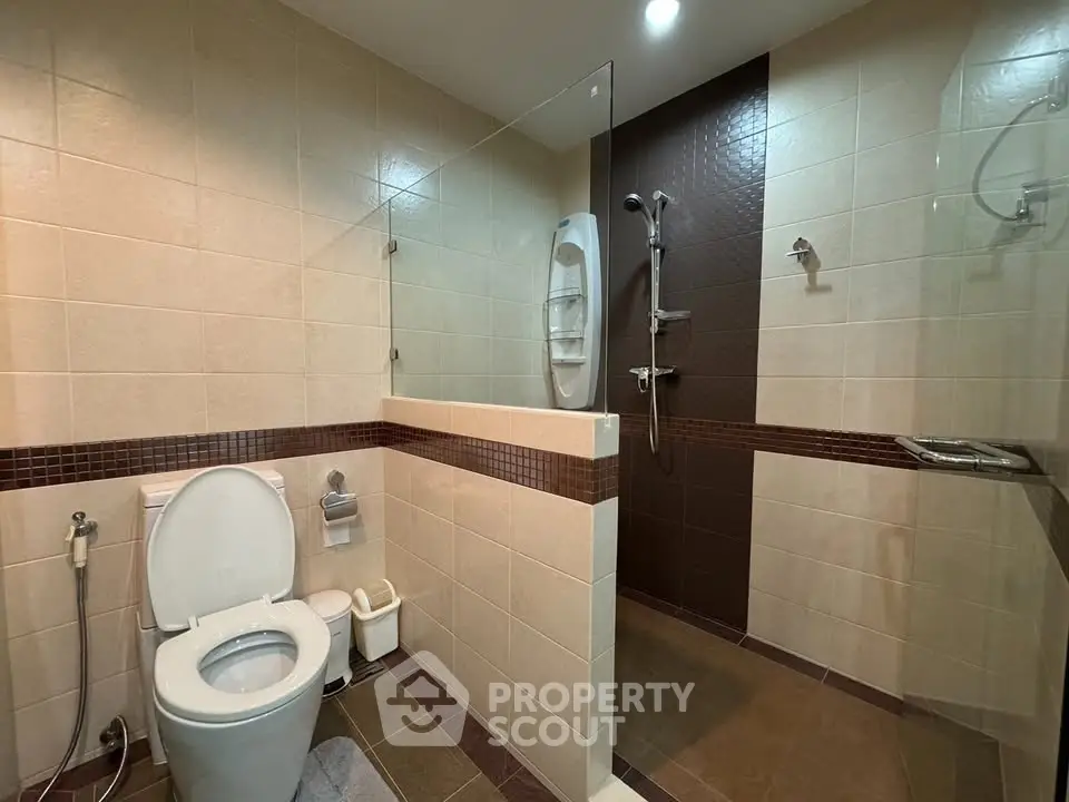 Modern bathroom with glass shower and tiled walls in elegant design.