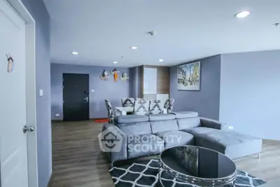 Spacious modern living room with stylish grey sofa and chic decor in a contemporary apartment.