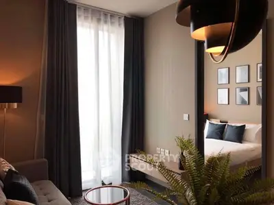 Modern living room with elegant decor and natural light, featuring a cozy sofa and stylish lighting.