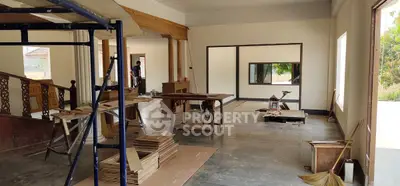 Spacious under-construction living room with large windows and wooden accents.