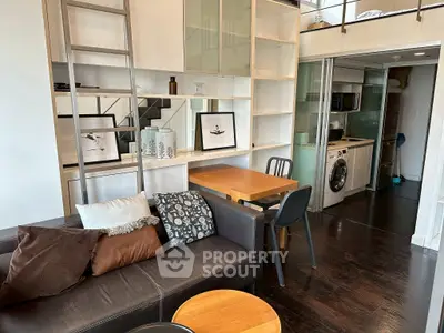 Modern loft apartment with stylish living area and compact kitchen featuring washing machine.